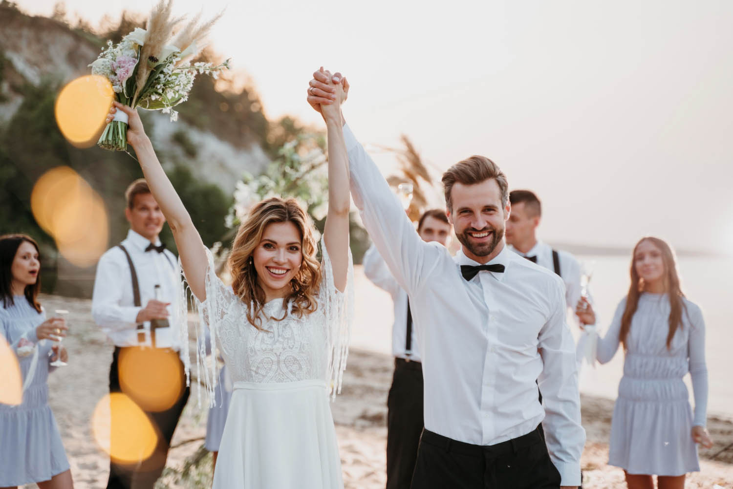 Bride and groom having their wedding with guests on the beach