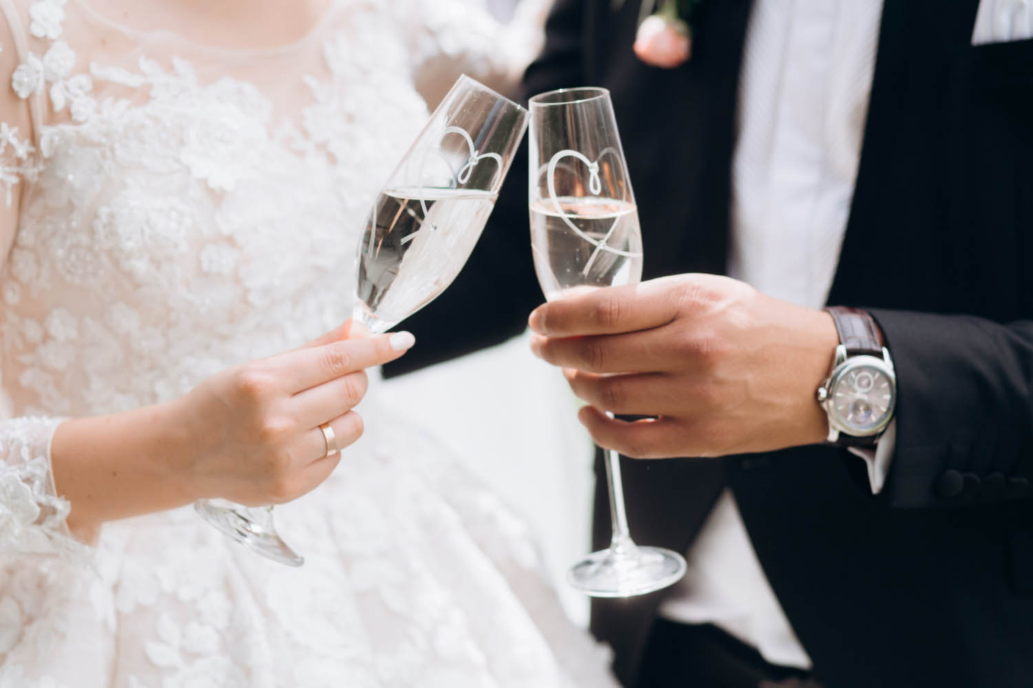 Groom and bride are knocking glasses of champagne